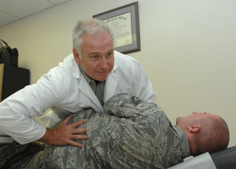 doctor helping soldier's back with orthopedic issues