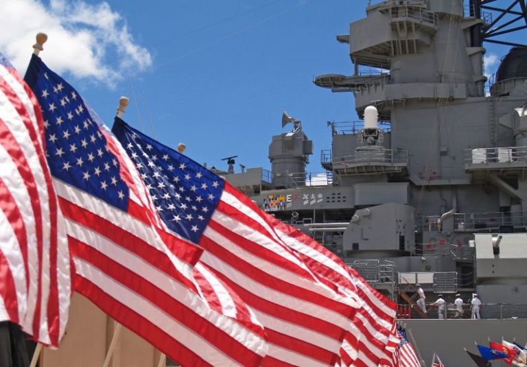 US flags in front of battleship