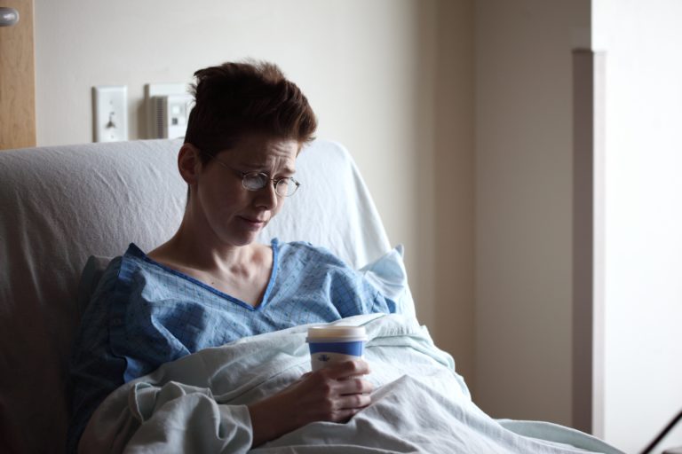 woman grasping coffee in hospital suffering lyme disease