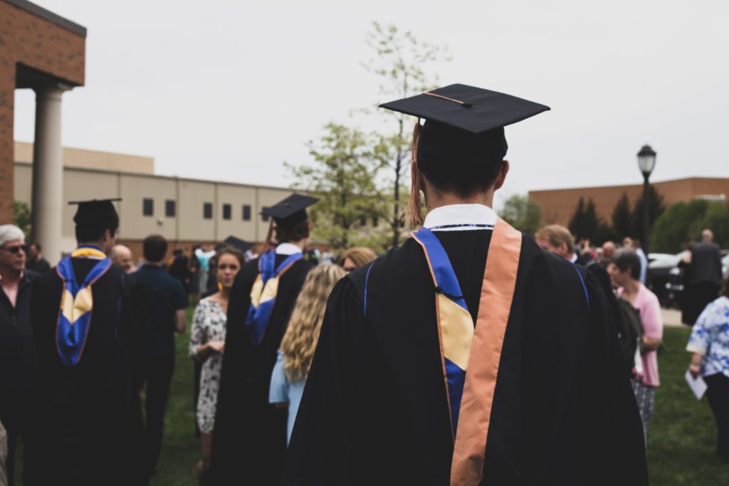 man with graduation cap and gown using post-9/11 gi bill