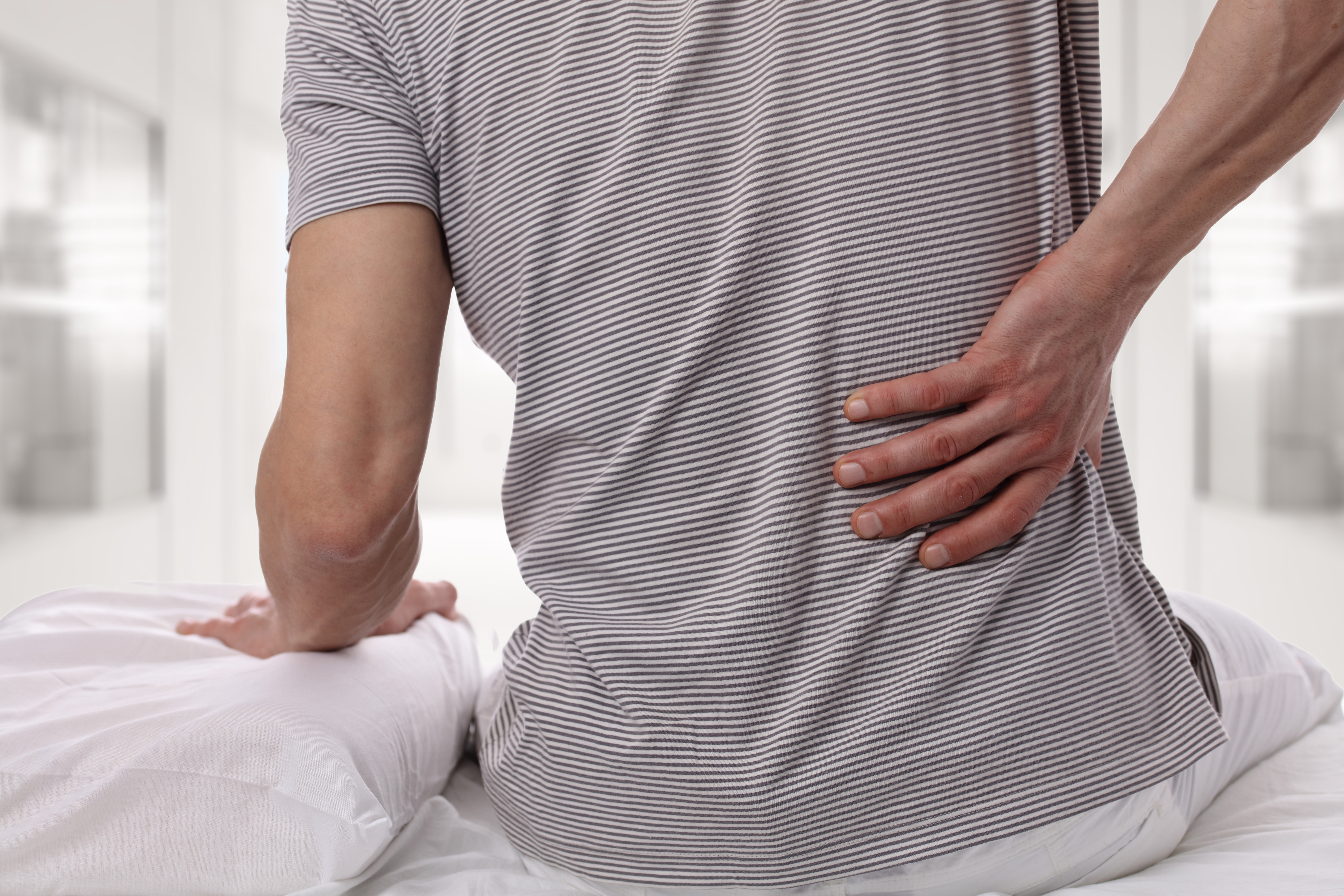man holding back in pain due to degenerative disc disease