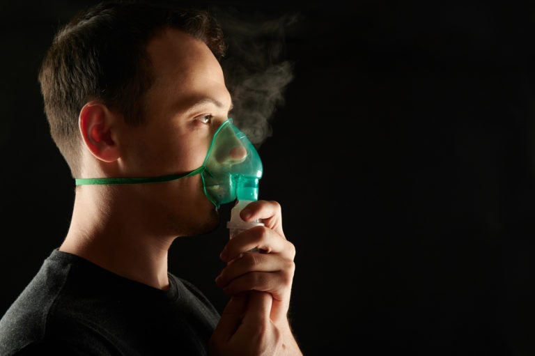 profile of man using nebulizer to treat asthma or sleep apnea