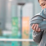 woman clutching elbow in pain due to tendonitis
