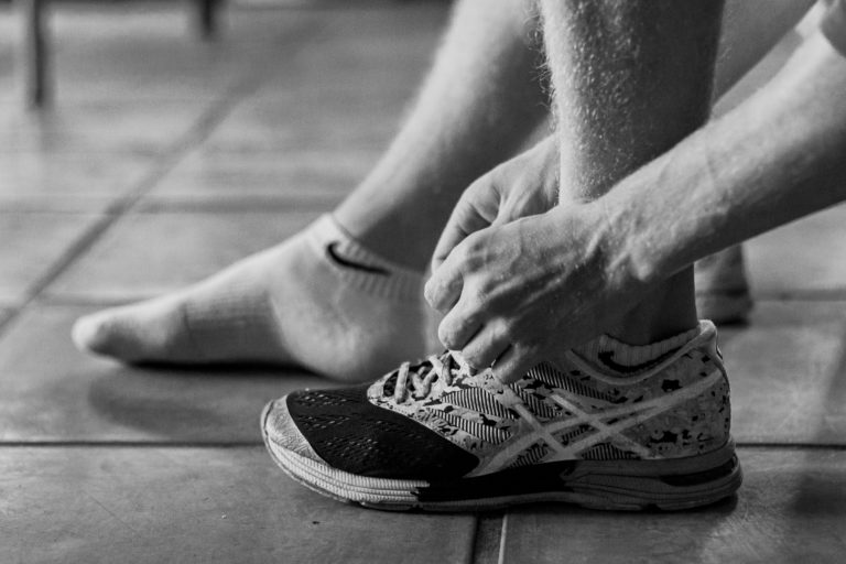 man lacing shoes, showing ankle instability