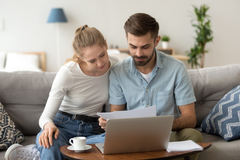 A couple looking at a computer and piece of paper, learning about the VA disability claim process.