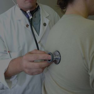doctor with stethoscope on mans back