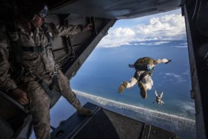 military men jumping out of plane