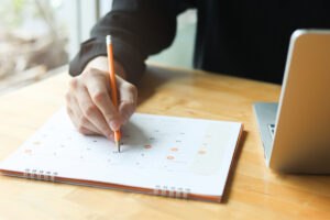 Person writing on a pad of paper, signifying the 5 essential factors of VA back pay.