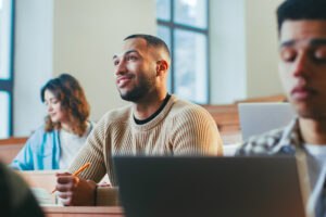 Man sitting in classroom at school.