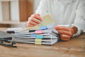 Closeup of person looking through packets of paper representing the VA OIG 2025 report.